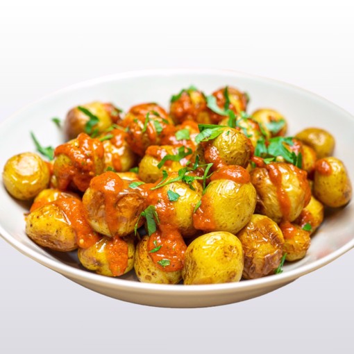 Bilde av bakte gourmetpoteter med salsa – ovnsbakte småpoteter krydret med flaksalt, toppet med en frisk og smakfull salsa samt ferske urter. Perfekt som tapasrett eller tilbehør.